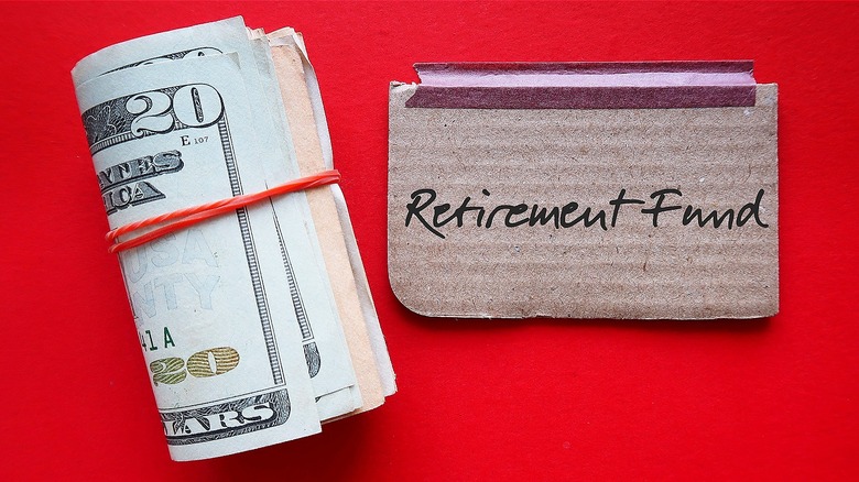 Roll of $20s next to cardboard piece reading 'retirement fund'