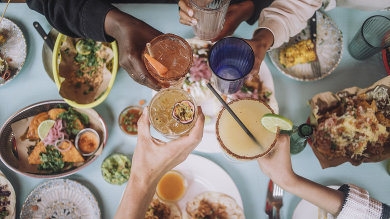 People clinking glasses together at restaurant