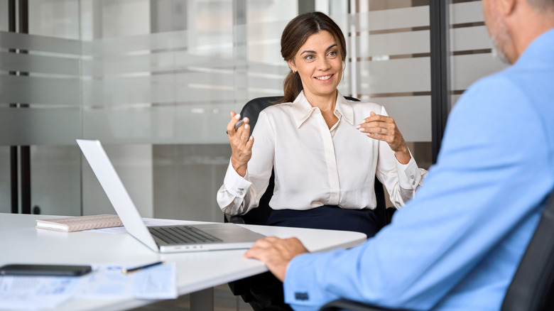 Two people talking to each other in a workplace.