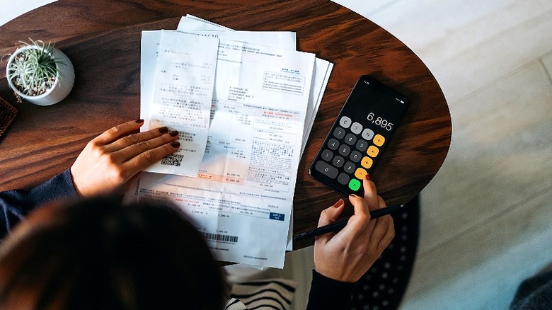 Person calculating expenses at table