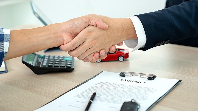 Car buyer and dealer handshake