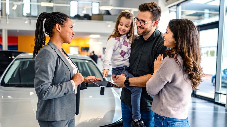 Family speaking with car salesperson