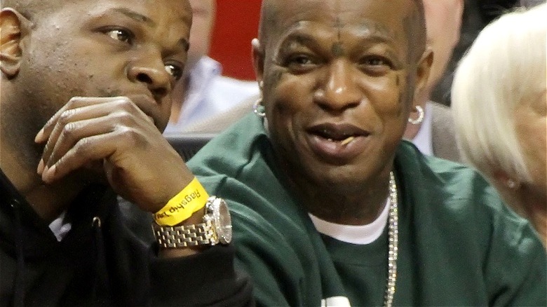 Birdman smiling while sitting courtside