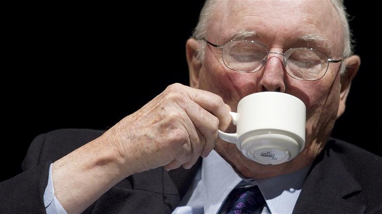 Charlie Munger drinking from cup