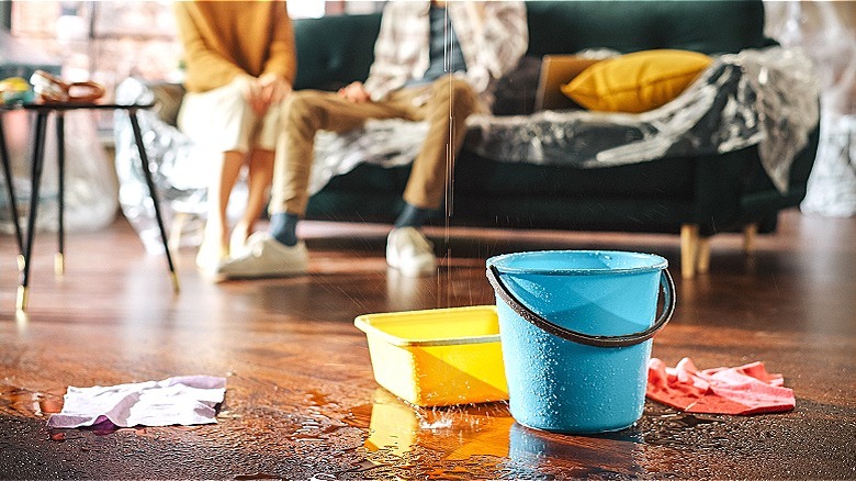 Water leaks into bucket and pan on floor of living room