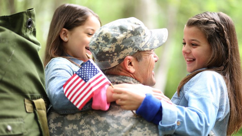 A veteran holding his daughters