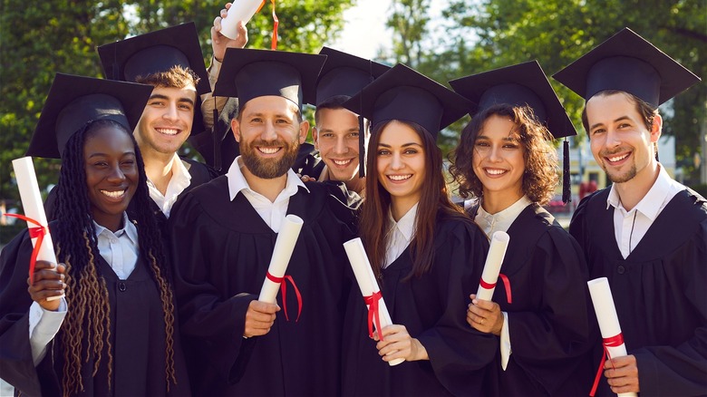 Happy college graduates holding degrees