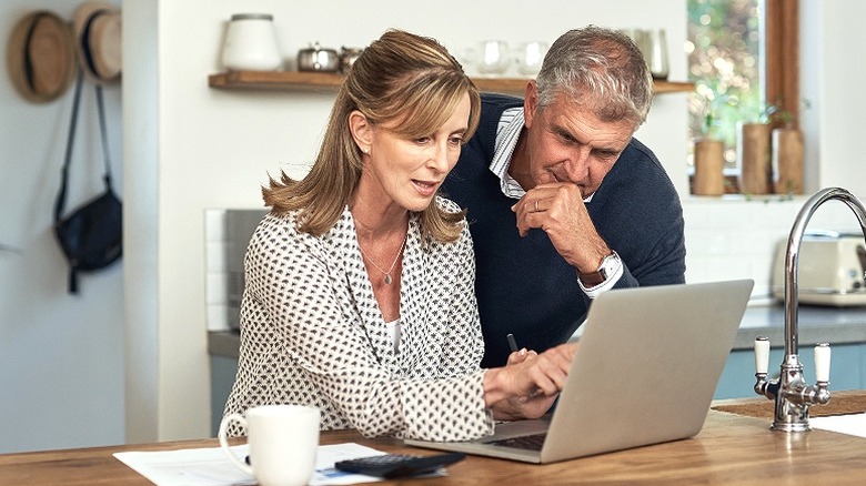 Couple reading laptop at home