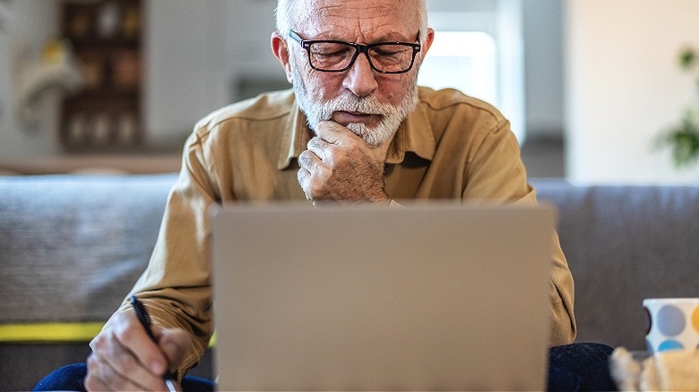 older American investing on laptop