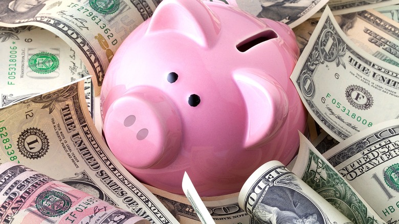 Piggy bank in money pile