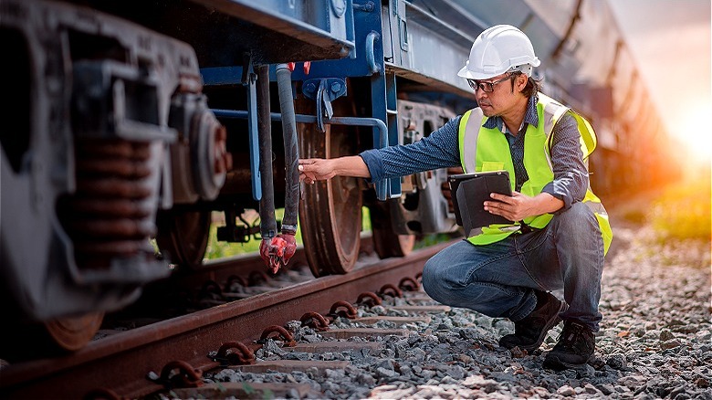 Person inspecting railroad train