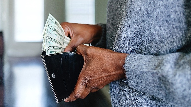 Consumer holding wallet and cash