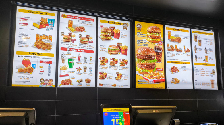 Menu board with a variety of burgers, fries, drinks, and meal combos