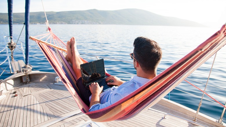 A man in a hammock on his laptop