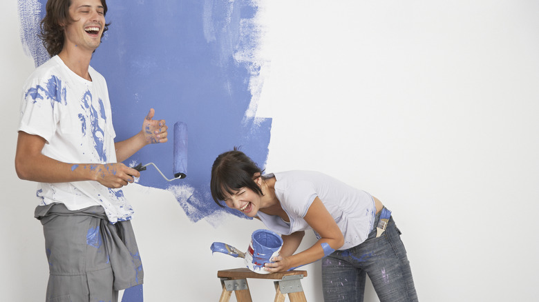 couple painting a room purple