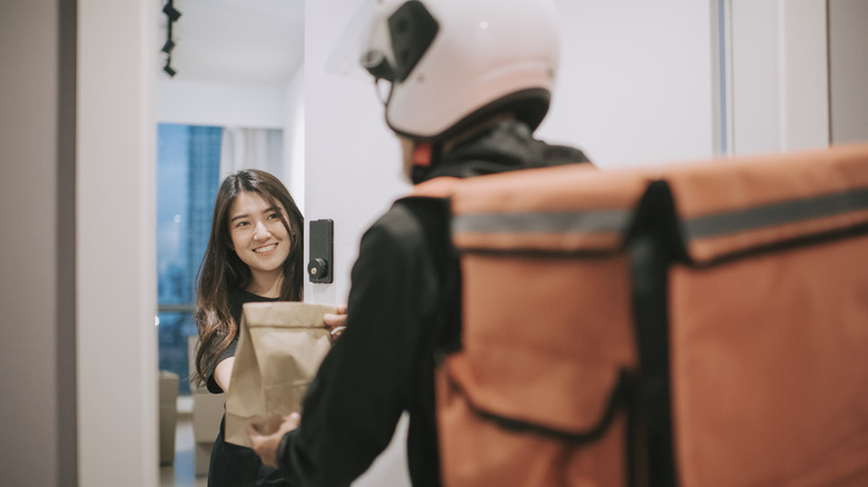 Person delivering food to woman