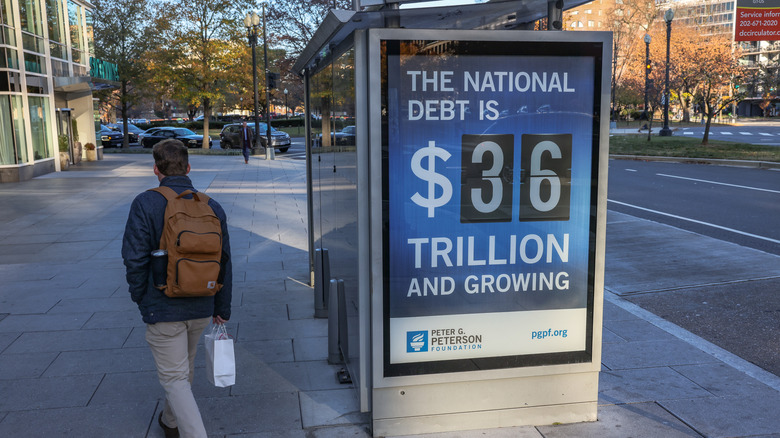 Bus sign listing current U.S. national debt