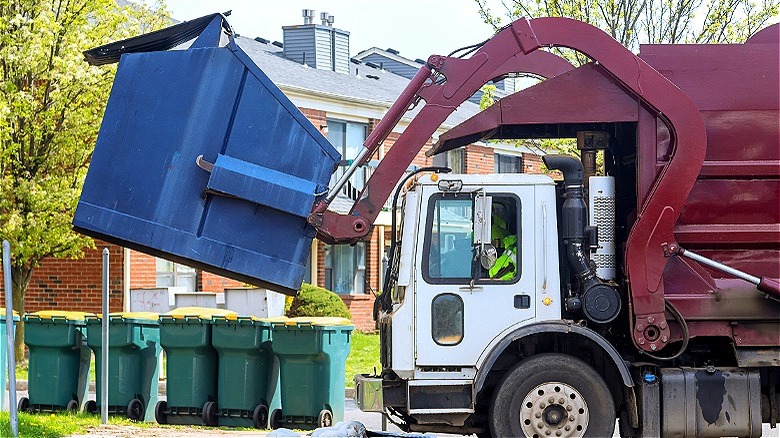 Garbage truck raising dumpster