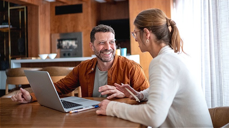 Couple smiling, looking at laptop