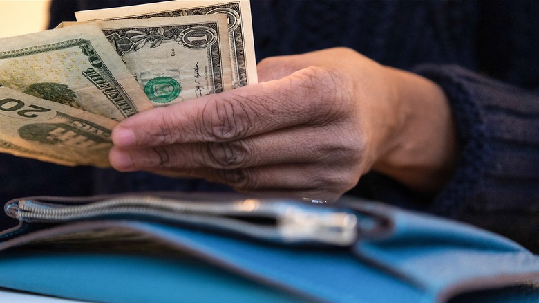 Person counting cash in their wallet