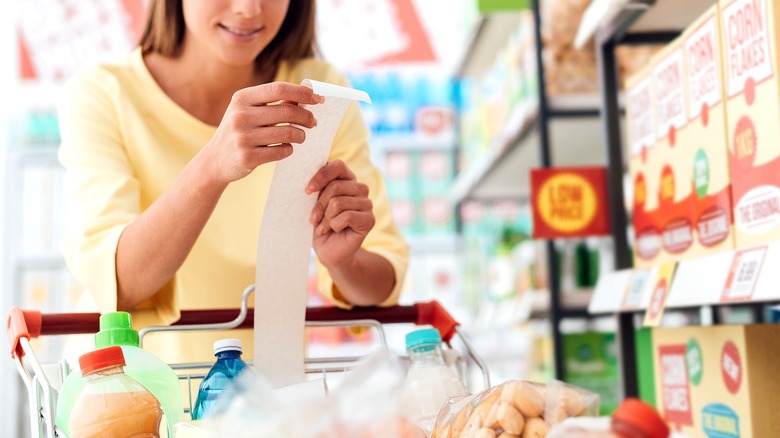 Person checking grocery shopping receipt