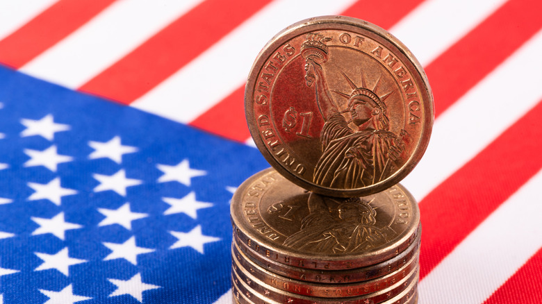 1 US dollar coin and American flag