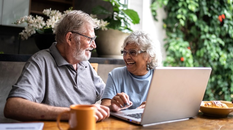 Older couple at laptop smiling
