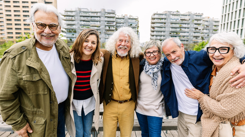 group of seniors plus an older woman posing for a picture