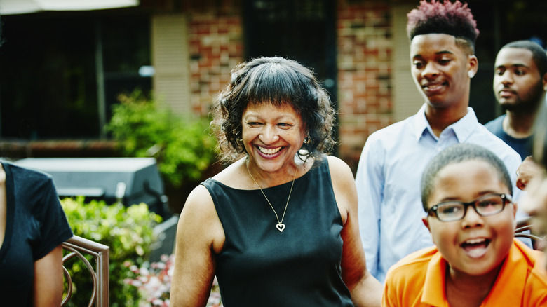 an elderly woman smiling while surrounded by children