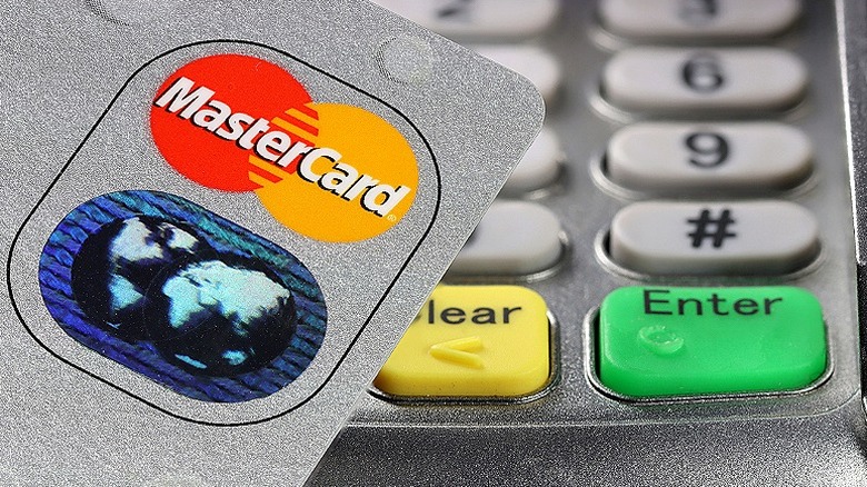 Close-up of Mastercard hologram logo and point-of-sale terminal