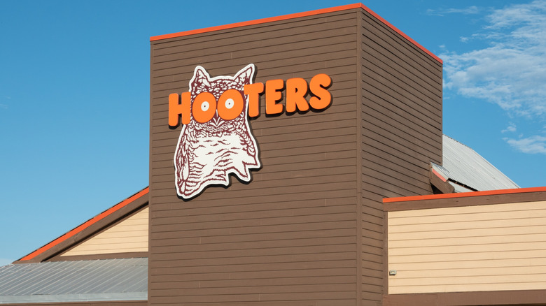 A massive brown Hooters storefront featuring the Hooters owl.