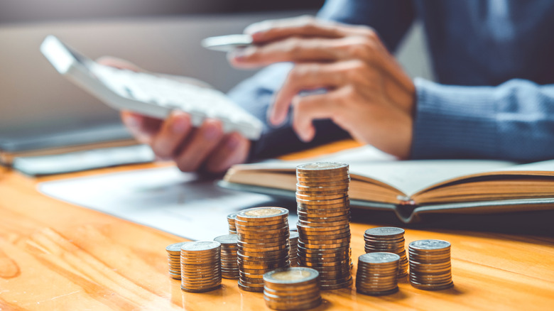 Investor calculating next to coins