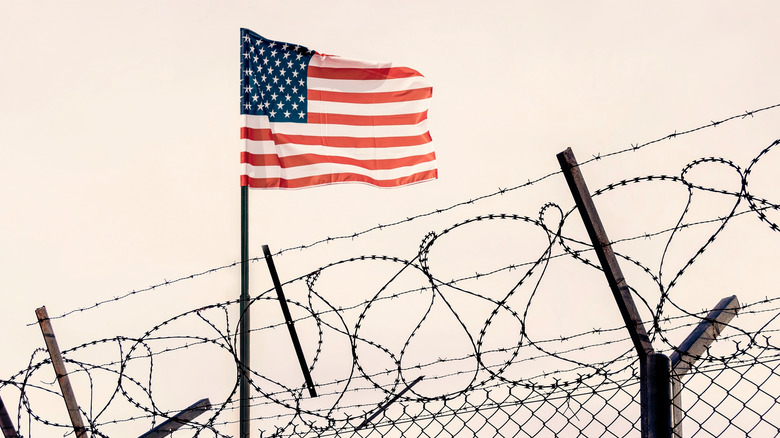 U.S. flag over a border fence