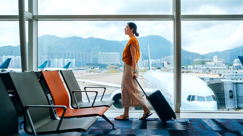 Person at airport, pulling luggage