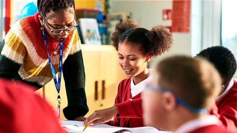 Teacher guiding an elementary student