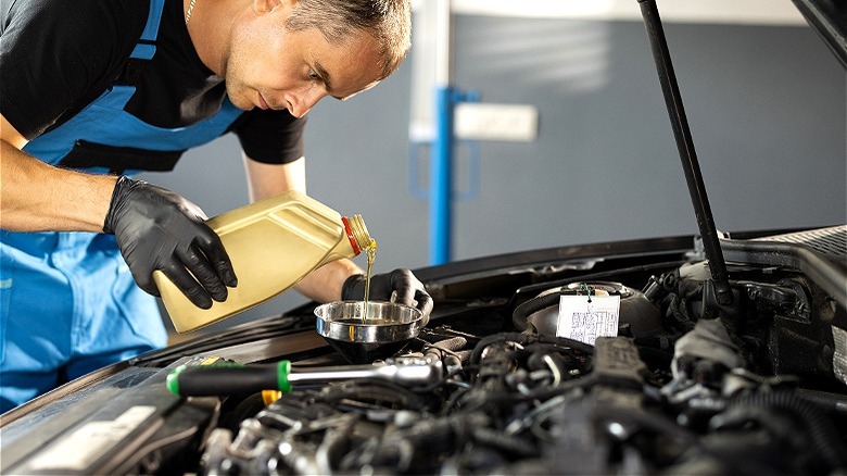 Person changing car engine oil
