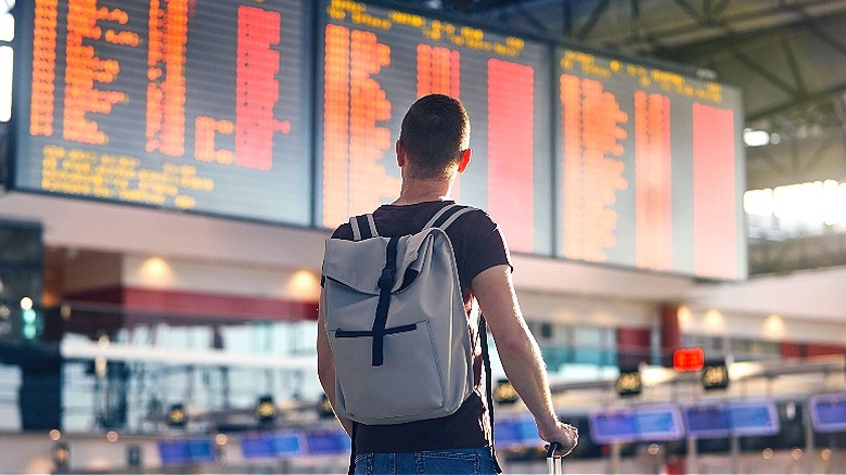 Traveler looking at airport arrivals