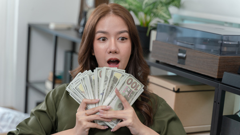 A woman is holding a bunch of money in her hands.