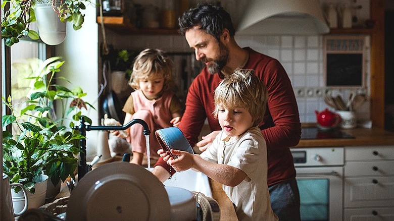 Kids help dad with dishes