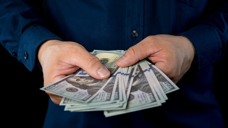 Man counting hundred dollar bills