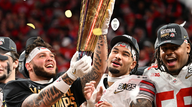 Ohio State college football athletes holding trophy