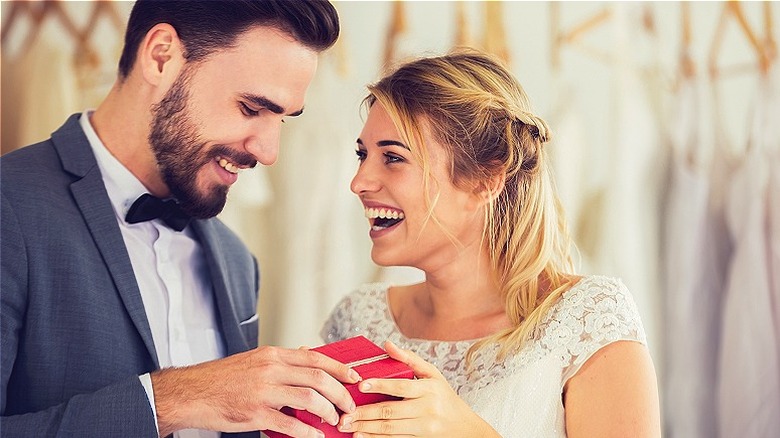 Couple smiling, opening wedding gift