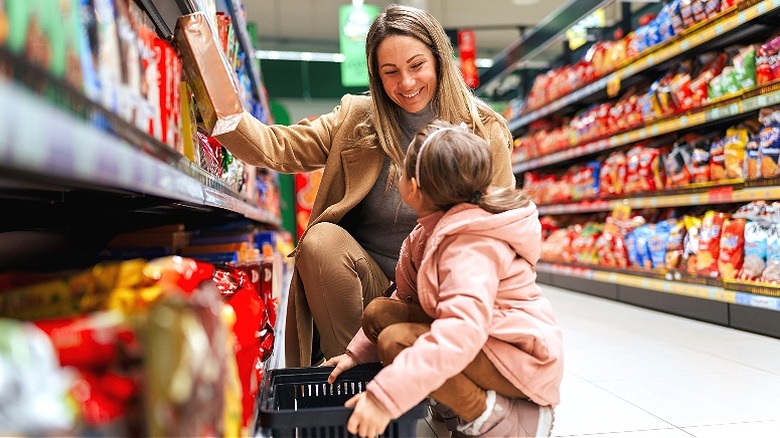 Mother grocery shopping with child