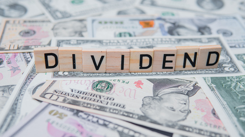 Dividend spelled out in wooden blocks on top of money