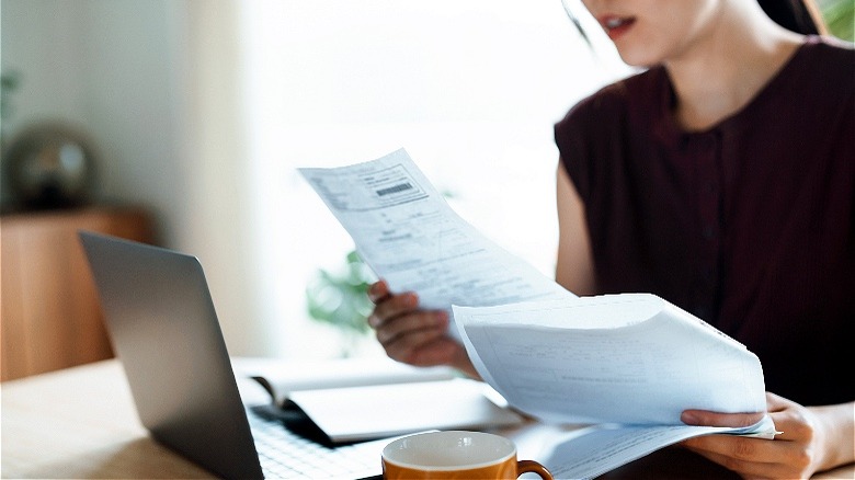 Person reviewing paperwork at home