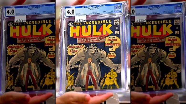 A person displays an encased copy of The Incredible Hulk #1