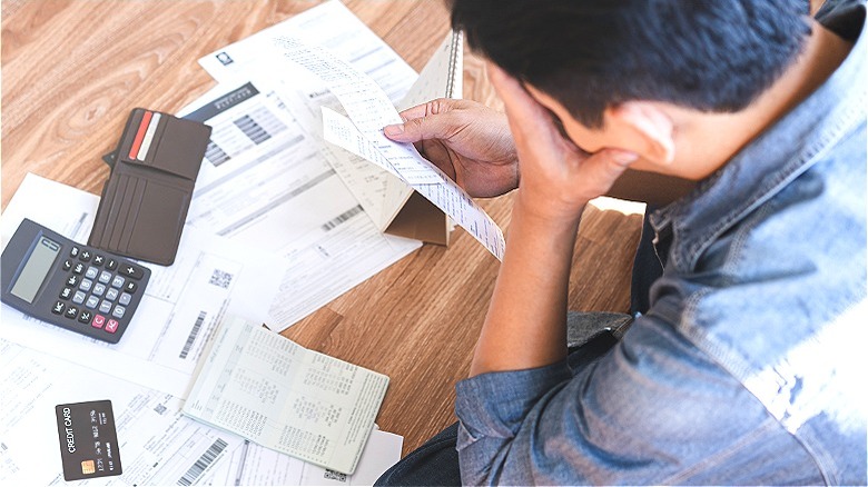 Person stressed calculating bill payments