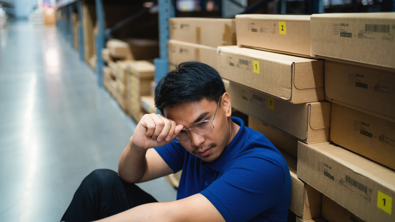 Worker contemplates warehouse supply issues