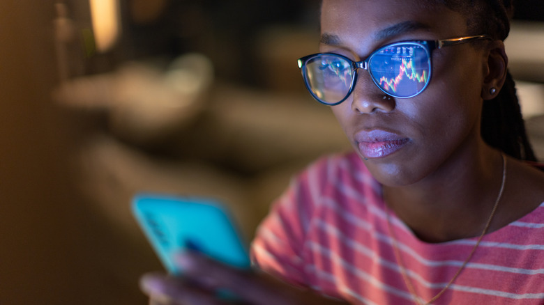 woman looking at stock market charts on phone