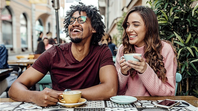 Two people laughing at cafe